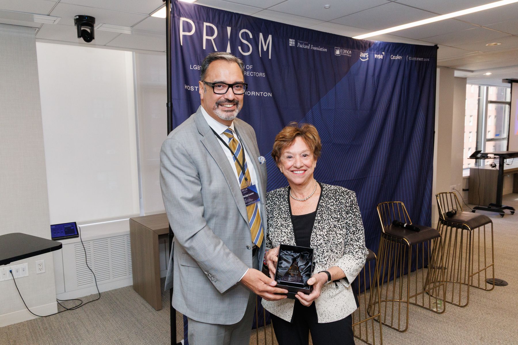 Michael Camuñez presents a Profiles in Excellence award to Betsy Bernard.